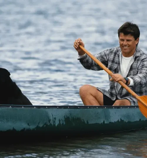 man and dog in canoe