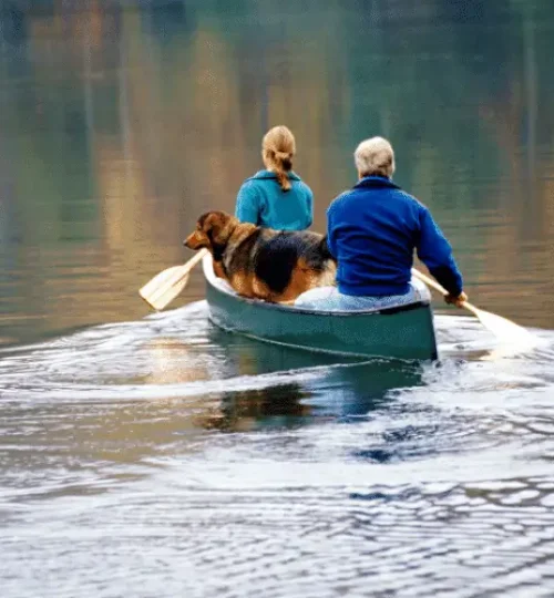 man woman in canoe with dog